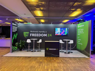 Freedom24 stand with a printed back wall, screen and high tables