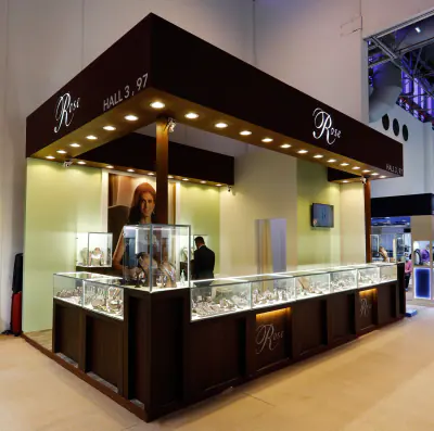 Dark timber jewellery kiosk with lit glass cases in a mall