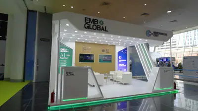 The EMB Global stand at ADNEC with its lit fascia and timber slat wall