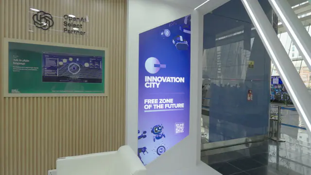 Detail of the timber slat wall with OpenAI Select Partner signage and a screen