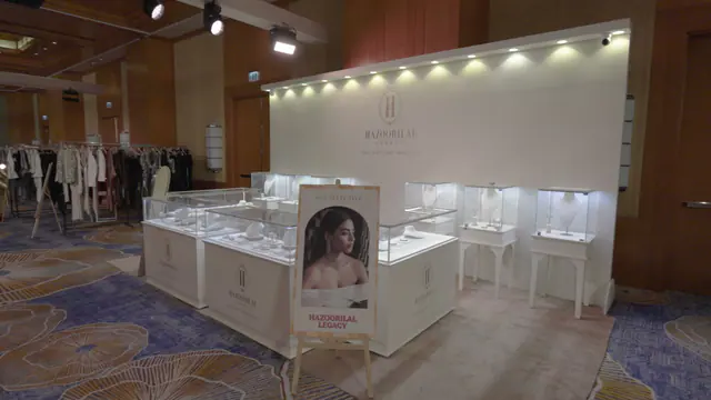 Row of glass vitrines with white jewellery busts under integrated lighting